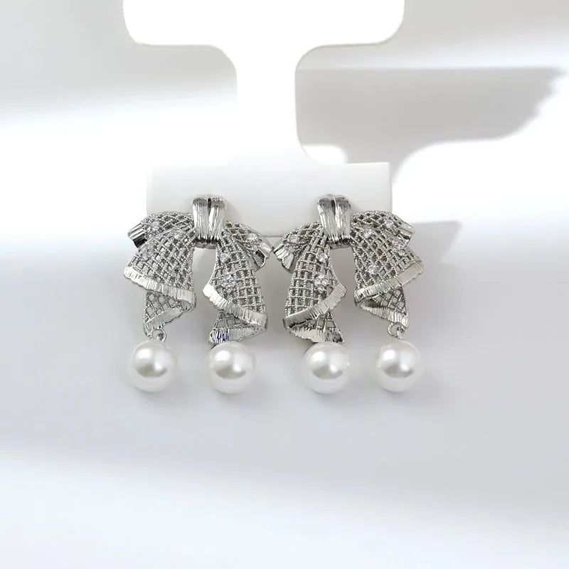 Hollow out large bow, exquisite mother shell pearl earrings, women's versatile earrings, fashionable and simple temperament