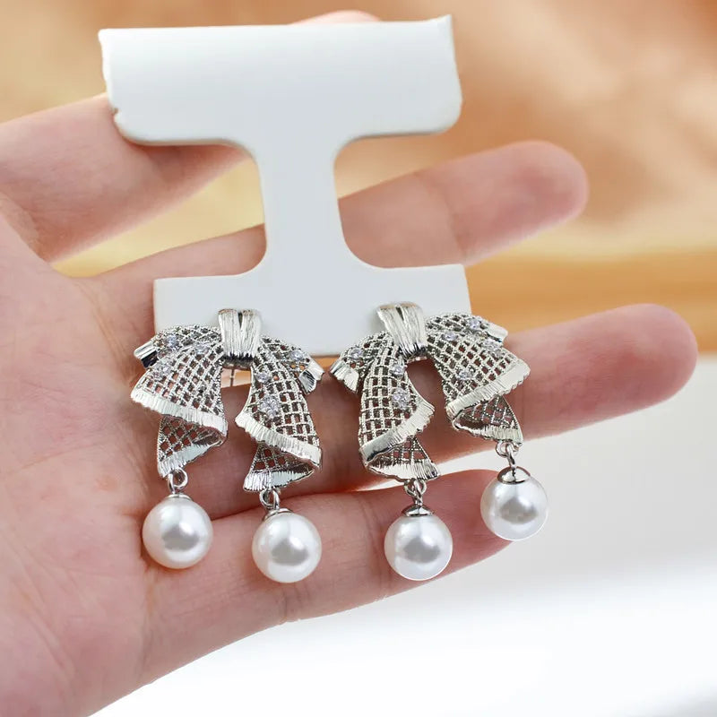 Hollow out large bow, exquisite mother shell pearl earrings, women's versatile earrings, fashionable and simple temperament