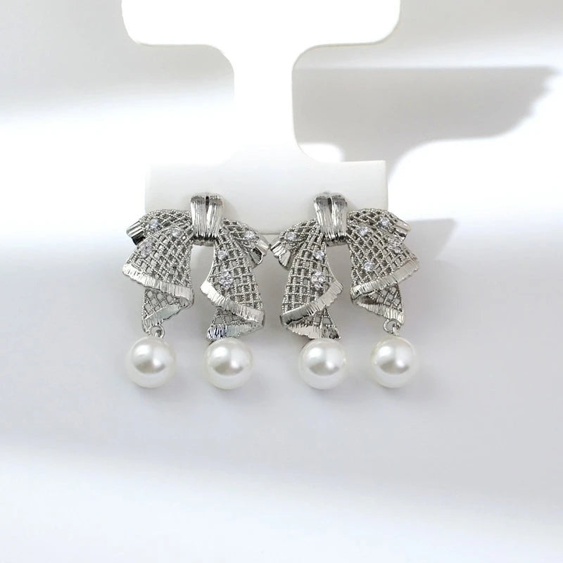Hollow out large bow, exquisite mother shell pearl earrings, women's versatile earrings, fashionable and simple temperament