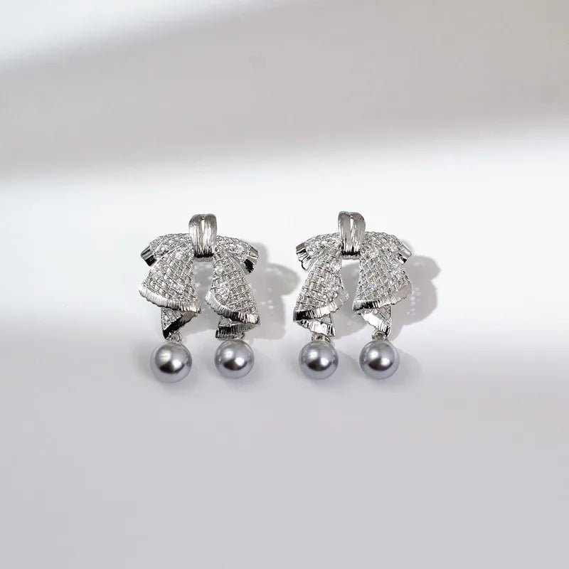 Hollow out large bow, exquisite mother shell pearl earrings, women's versatile earrings, fashionable and simple temperament